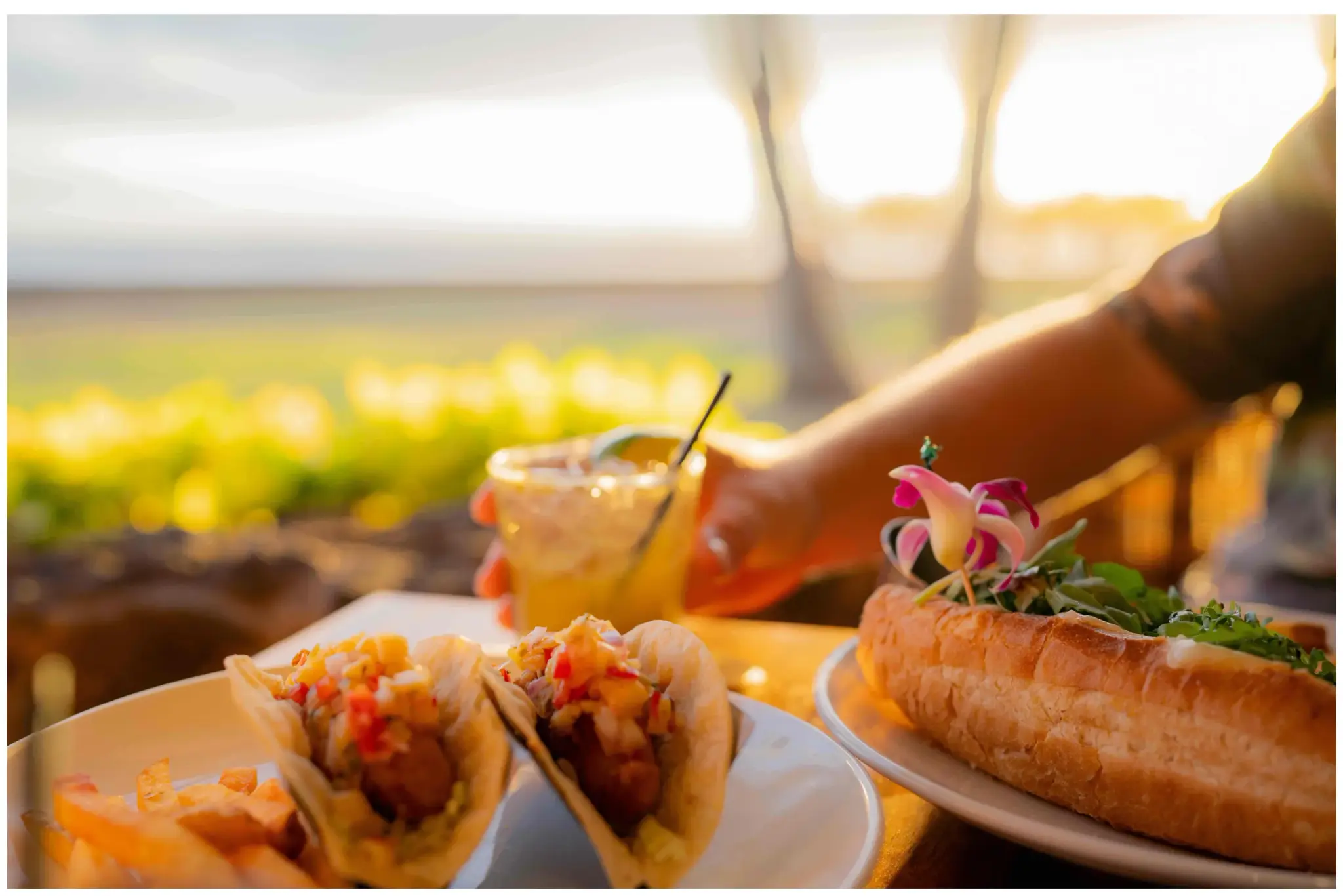 Fish tacos and a cocktail on the rail at Kona Inn Restaurant as the sun sets over Kailua Bay