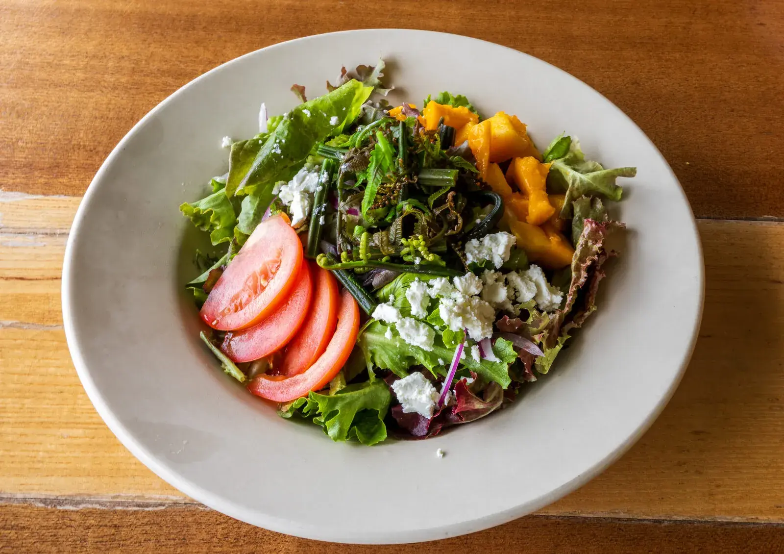Kona Inn Harvest Salad with mixed greens, goat cheese, seasonal fruit and sherry vinaigrette