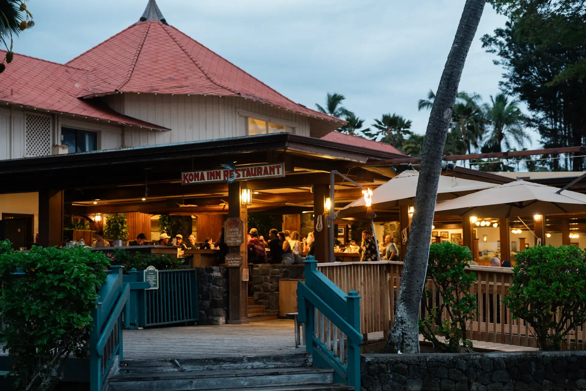 Kona Inn Restaurant storefront glowing at dusk along the Aliʻi Drive waterfront walkway