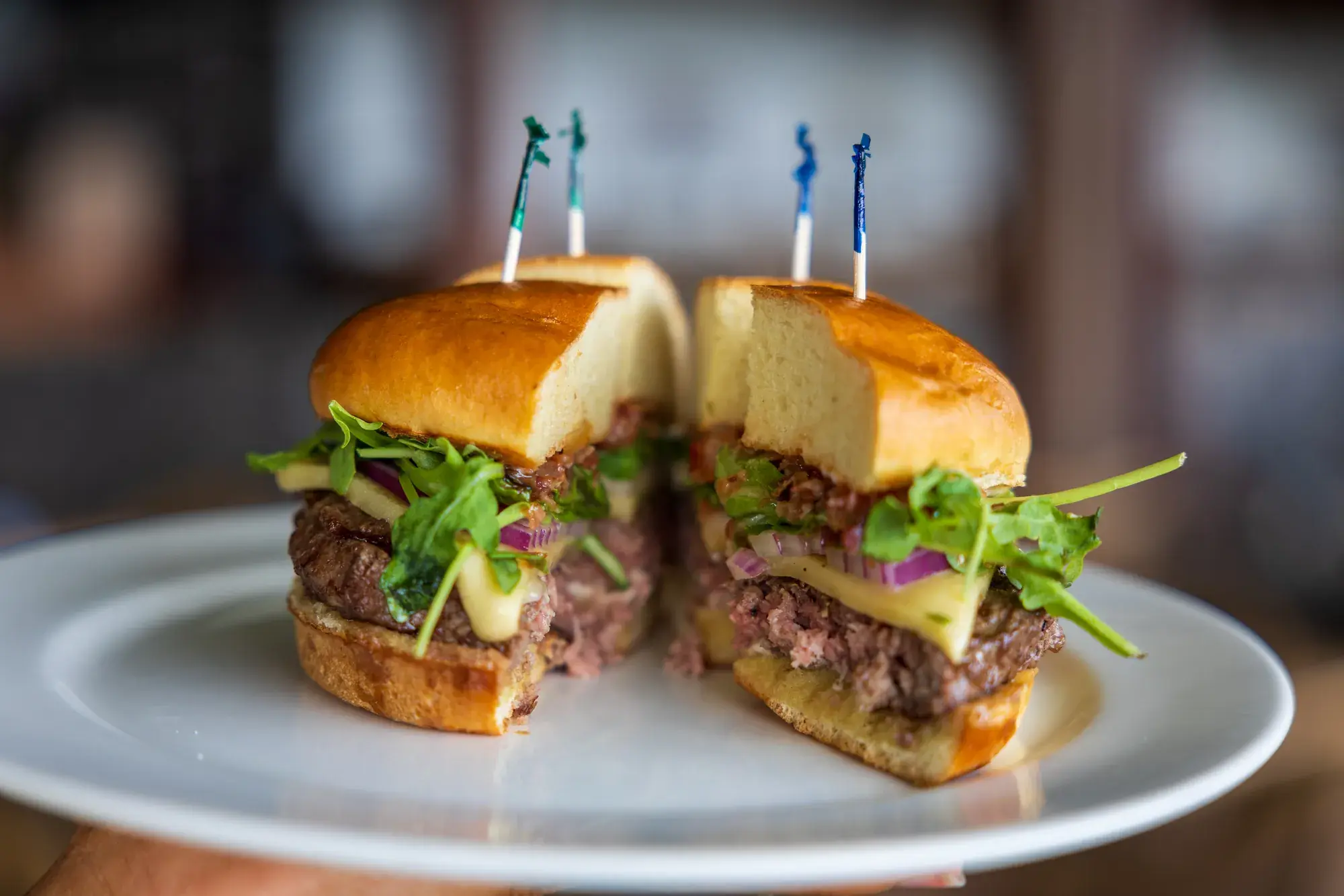 Aliʻi Burger at Kona Inn Restaurant, Wagyu blend, brioche bun, guava bacon onion jam, smoked gouda, red onions, arugula, with French fries.